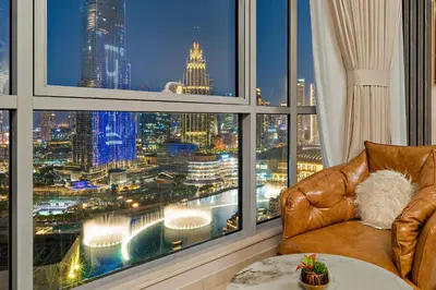 a living room with a view of a city from a window at Ace Luxe, 2BR, Downtown, Burj Khalifa & Dubai Fountain view, 5 mins walk to Dubai Mall in Dubai
