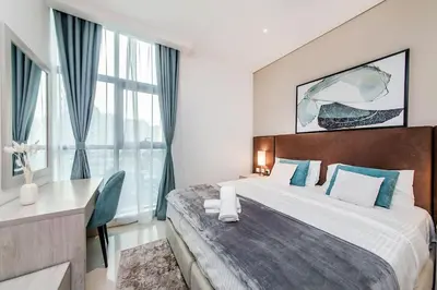 a bedroom with a large bed and a window at Cozy studio in Seven Palm in Dubai