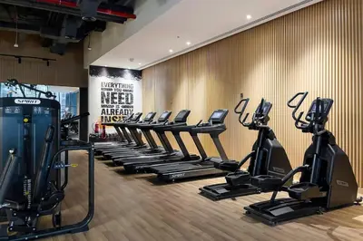 a gym with a row of treadmills and ellipticals at Cozy studio in Seven Palm in Dubai