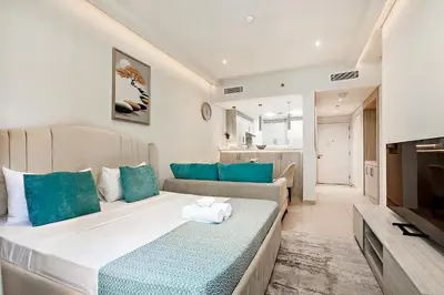 a living room with a large bed and a couch at Lovely 1BR in Seven Palm in Dubai