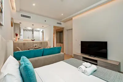 a living room with a couch and a television at Lovely 1BR in Seven Palm in Dubai