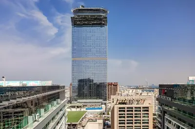 a tall skyscraper in the middle of a city at Lovely 1BR in Seven Palm in Dubai