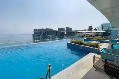 a large swimming pool on the roof of a building at Lovely 1BR in Seven Palm in Dubai