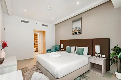 a bedroom with a large white bed in a room at Lovely 1BR in Seven Palm in Dubai