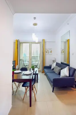 a living room with a blue couch and a table at Superb 1Bed Marina View pool JBR Beach Parking in Dubai