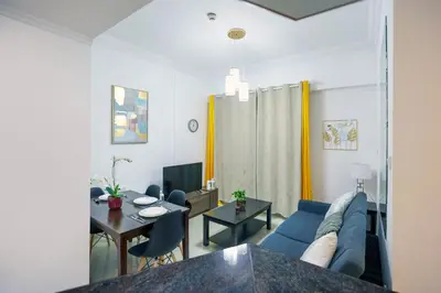 a living room with a blue couch and a table at Superb 1Bed Marina View pool JBR Beach Parking in Dubai