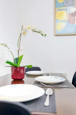 a table with white plates and a plant on it at Superb 1Bed Marina View pool JBR Beach Parking in Dubai