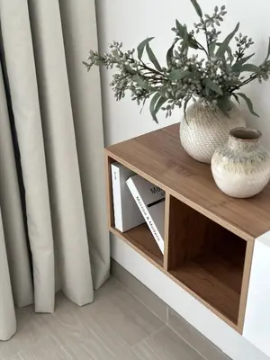 a shelf with a vase and flowers on it at Cozy studio apartment in Jumeirah Village Circle in Dubai
