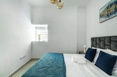 a bedroom with a large bed with blue pillows at ShoresInn - Magnificent 1BR in Dubai Marina in Dubai
