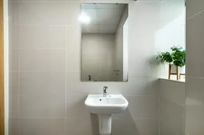 a white bathroom with a sink and a mirror at ShoresInn - Magnificent 1BR in Dubai Marina in Dubai