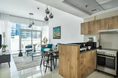 a kitchen and living room with a table and chairs at ShoresInn - Magnificent 1BR in Dubai Marina in Dubai