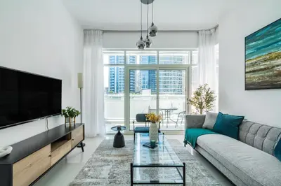 a living room with a couch and a tv at ShoresInn - Magnificent 1BR in Dubai Marina in Dubai