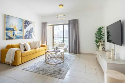 a living room with a yellow couch and a table at Frank Porter - Al Arta 4 in Dubai