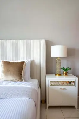 a bedroom with a bed and a table with a lamp at Frank Porter - Al Arta 4 in Dubai