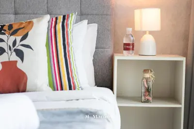 a bedroom with a bed with a lamp and a side table at Manzil - Stylish living in JVC, City Views and Pool in Dubai