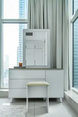 a white dresser with a mirror in a room with windows at ShoresInn - Stellar 2BR with charming Marina View in Dubai