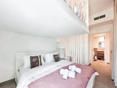 a bedroom with a large bed with two towels on it at Cozy 1 Bedroom in Golfville Dubai Hills in Dubai