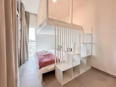 a bedroom with a bed and a book shelf at Cozy 1 Bedroom in Golfville Dubai Hills in Dubai