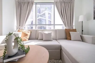 a living room with a white couch and a large window at Mystic - Stylish High-Rise Living with Premium Amenities in Dubai