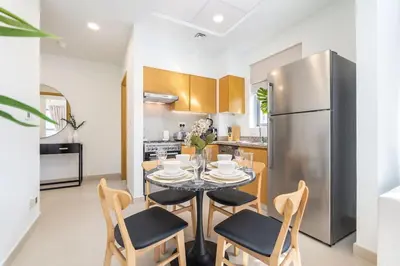 a kitchen with a table and chairs and a refrigerator at Mystic - Stylish High-Rise Living with Premium Amenities in Dubai