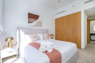 a bedroom with a white bed with two towels on it at Mystic - Stylish High-Rise Living with Premium Amenities in Dubai