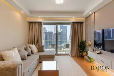 a living room with a couch and a large window at The Elegant Escape in Dubai