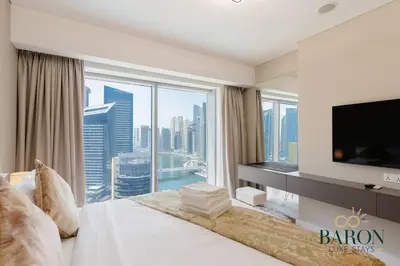 a hotel room with a large bedroom with a large window at The Elegant Escape in Dubai