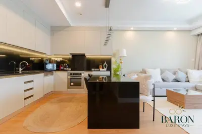 a kitchen and living room with a couch and a table at The Elegant Escape in Dubai
