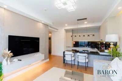 a kitchen and living room with a large screen tv at The Elegant Escape in Dubai