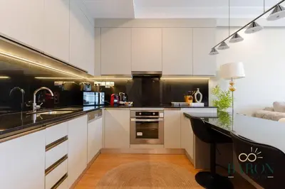 a kitchen with white cabinets and a black counter top at The Elegant Escape in Dubai