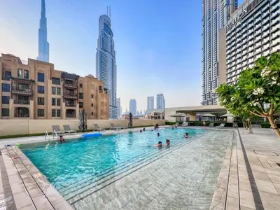 a swimming pool in a city with people in it at Burj Royale - Luxury Stay with Panoramic Burj Khalifa & Fountain View in Dubai