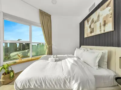 a bedroom with a large white bed with a window at Stunning Panoramic Sea & Marina Skyline View in Dubai