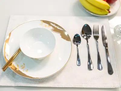 a table with a plate and spoon and fork and knife at Stunning Panoramic Sea & Marina Skyline View in Dubai