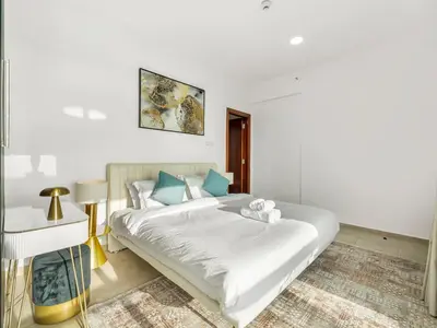 a bedroom with a large white bed with blue pillows at Stunning Panoramic Sea & Marina Skyline View in Dubai