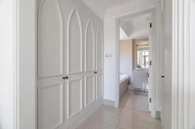a white hallway with white cabinets and a bathroom at GuestReady - Downtown lux near Burj Khalifa in Dubai