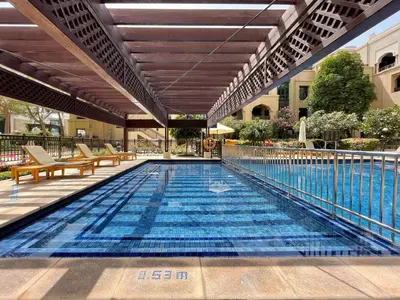 a swimming pool with chairs and a building at GuestReady - Downtown lux near Burj Khalifa in Dubai