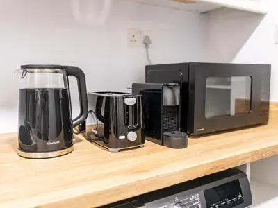 a counter with a microwave and appliances on it at Elegant Dubai Eye Beach Retreat in Dubai
