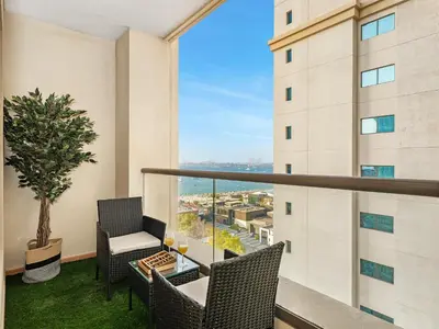 a balcony with chairs and a table with a view at Elegant Dubai Eye Beach Retreat in Dubai