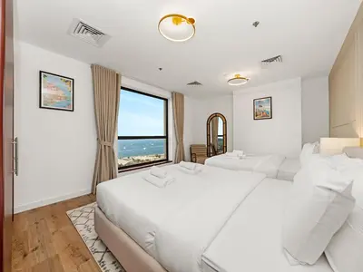 a bedroom with two beds and a large window at Elegant Dubai Eye Beach Retreat in Dubai