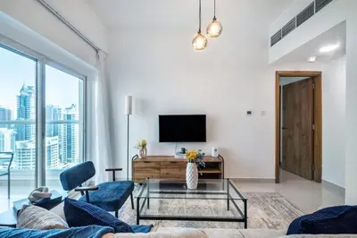 a living room with a couch and a tv at ShoresInn - Stunning 1BR with Marina View in Dubai