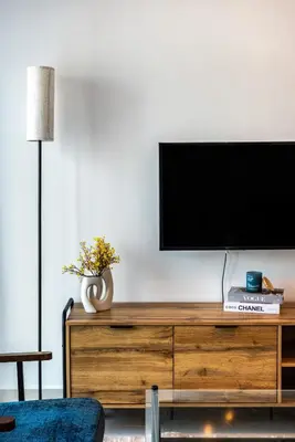 a flat screen tv sitting on top of a wooden dresser at ShoresInn - Stunning 1BR with Marina View in Dubai