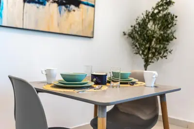 a table with plates and glasses on it at ShoresInn - Stunning 1BR with Marina View in Dubai