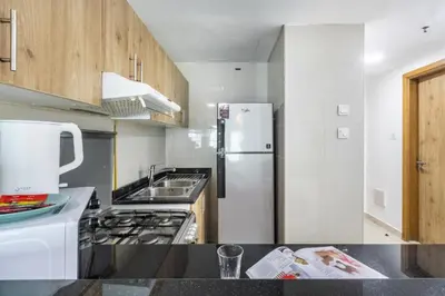 a kitchen with a white refrigerator and a sink at ShoresInn - Stunning 1BR with Marina View in Dubai