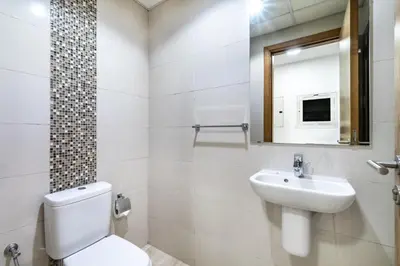 a bathroom with a toilet and a sink and a mirror at ShoresInn - Stunning 1BR with Marina View in Dubai