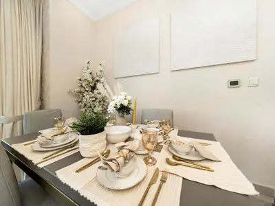 a dining room table with plates and silverware on it at Bespoke 1 Bedroom Apartment I Burj Khalifa & Fountain Views I Free Gym, Pool, Wi-Fi, Parking & PS5 I by Skyline Serenity in Dubai