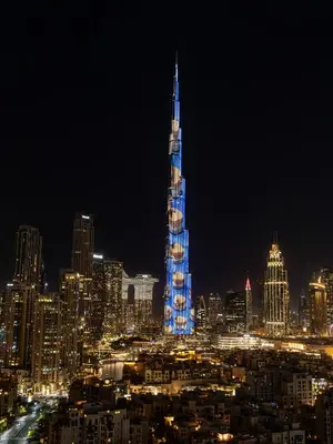 a lit up skyscraper in a city at night at Bespoke 1 Bedroom Apartment I Burj Khalifa & Fountain Views I Free Gym, Pool, Wi-Fi, Parking & PS5 I by Skyline Serenity in Dubai