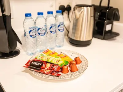 a plate of snacks and bottles of water on a counter at Luxe 4 bedroom Apartment I Burj Khalifa & Fountain Views I Free Gym, Pool, Parking, Wi-Fi and PS5 I by Skyline Serenity in Dubai