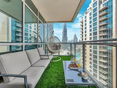 a living room with a couch and a swing at Luxe 4 bedroom Apartment I Burj Khalifa & Fountain Views I Free Gym, Pool, Parking, Wi-Fi and PS5 I by Skyline Serenity in Dubai