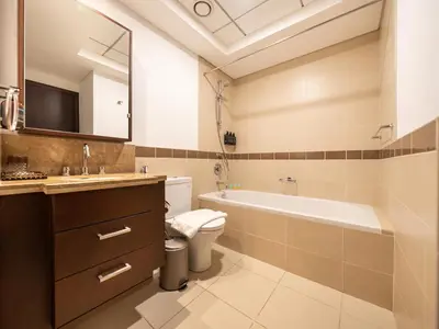 a bathroom with a tub and a toilet and a sink at New Burj Khalifa & Fountain Views & Work station in Dubai