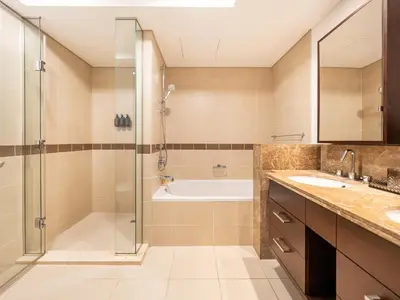 a bathroom with a shower and a tub and a sink at New Burj Khalifa & Fountain Views & Work station in Dubai